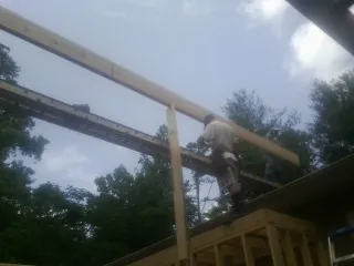 Carpenter setting a ridge beam over a new addition frame — Ice Dam Removal by Roofing Brothers in Morristown
