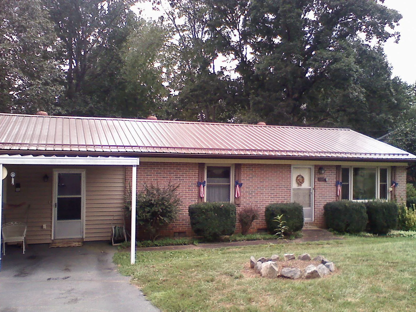 Bronze metal roof and carport on a brick ranch home — Roof Repair work by our crew in Morristown
